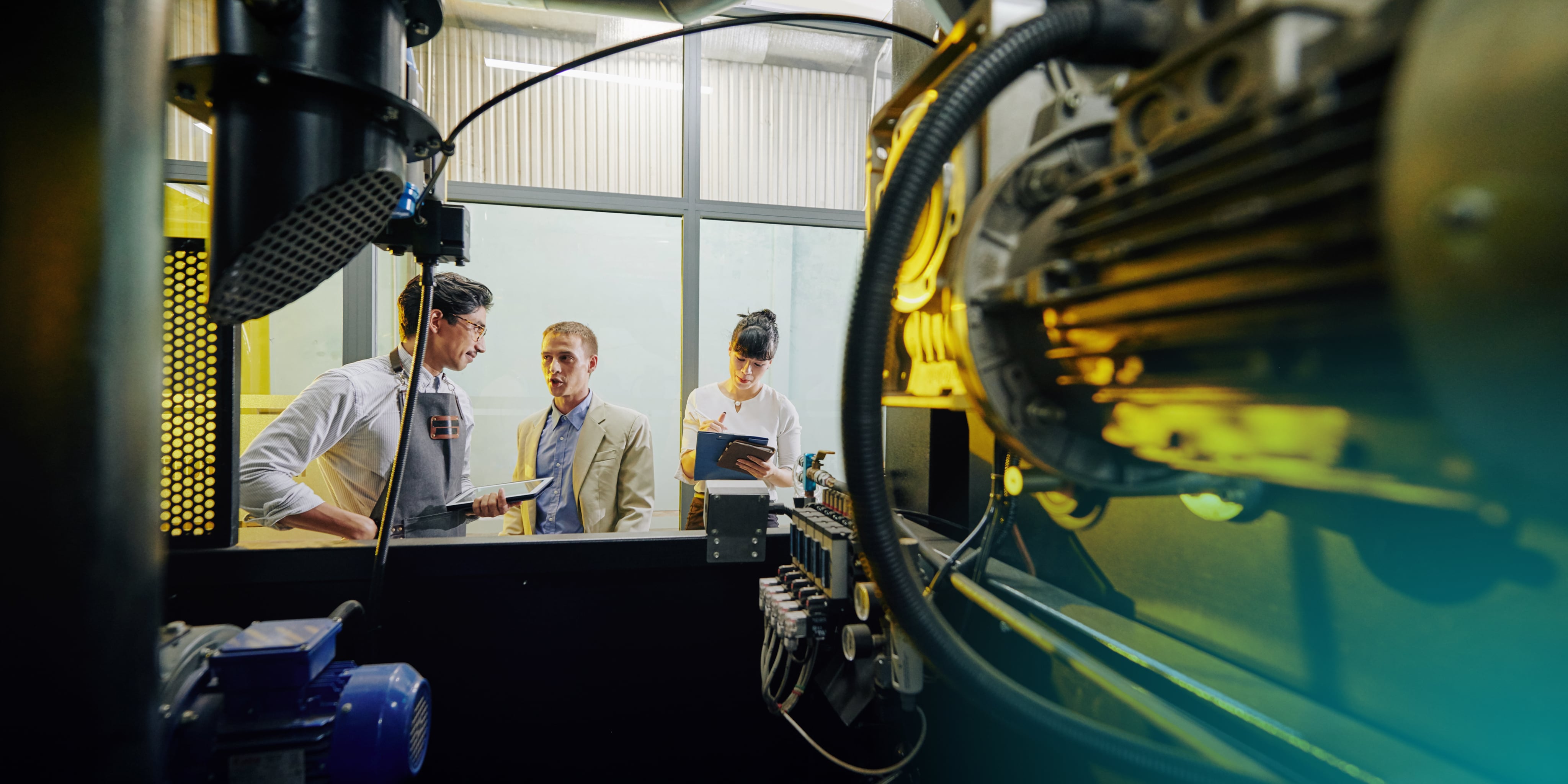 Team Discussing Industrial Machinery at Workplace